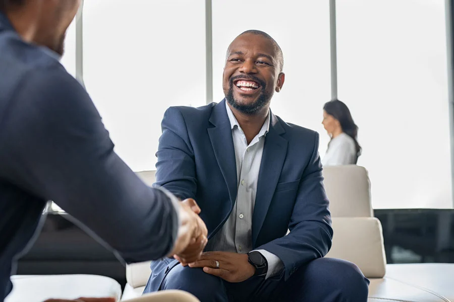System Integrator Program image of two men shaking hands in a bright office space
