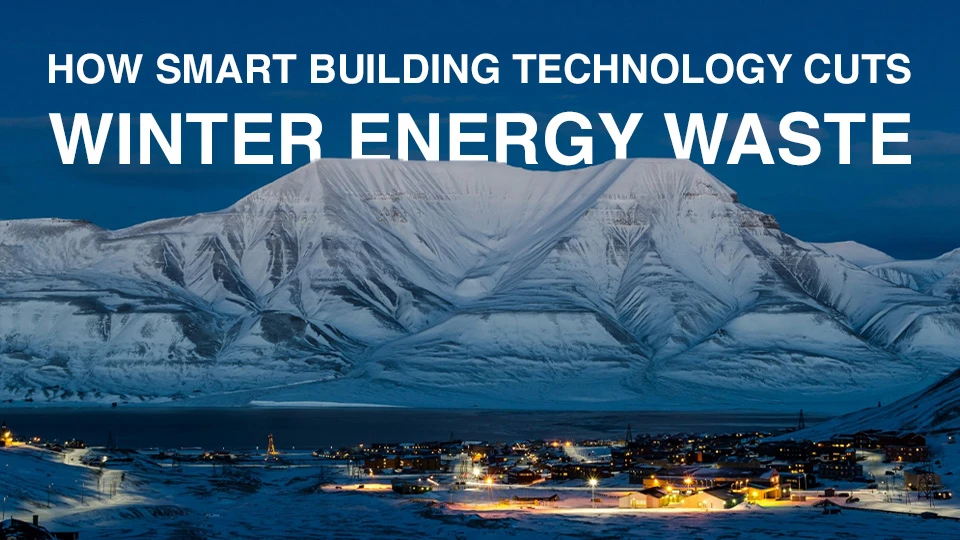 A nighttime photo of the illuminated buildings in the Arctic town of Longyearbyen, with snow-covered mountains in the background, highlighting reducing winter energy waste through smart building tech